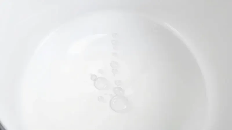 Gotas de água deslizando sobre uma superfície de cerâmica branca limpa demonstrando facilidade de limpeza.